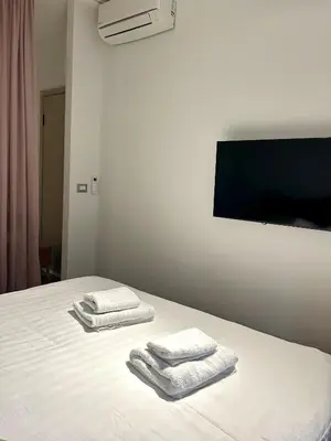 two towels on a bed with a tv on the wall at Luxury Nest Ponte Milvio in Rome
