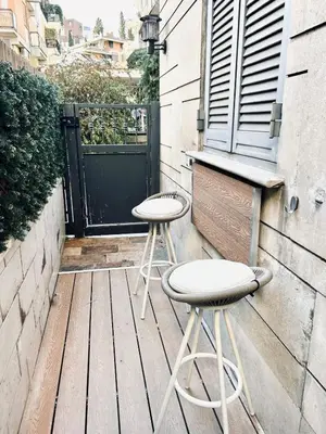 a pair of stools sitting on a wooden deck at Luxury Nest Ponte Milvio in Rome