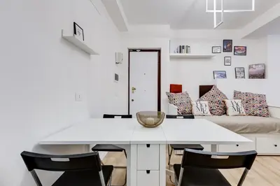 a white dining room table with chairs and a couch at New opening Ponte Milvio in Rome