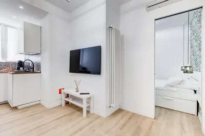 a white room with a bed and a tv on a wall at New opening Ponte Milvio in Rome