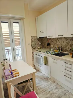 a kitchen with white cabinets and a table and a counter at B&B A casa da Mami in Rome