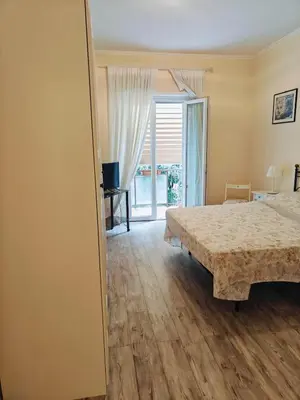 a bedroom with a bed and a sliding glass door at B&B A casa da Mami in Rome