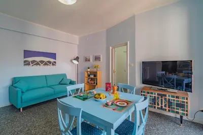 a living room with a table and a blue couch at Roma 1950 - Bright apartment in octagonal tower in Rome