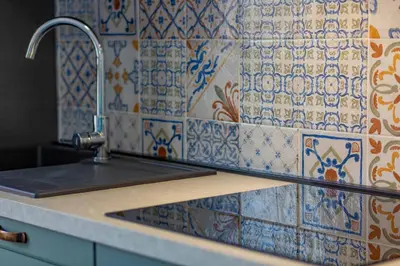 a kitchen with a sink and a tile wall at Roma 1950 - Bright apartment in octagonal tower in Rome