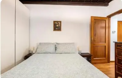 a bedroom with a large bed and a wooden cabinet at Piazza Farnese house in Rome