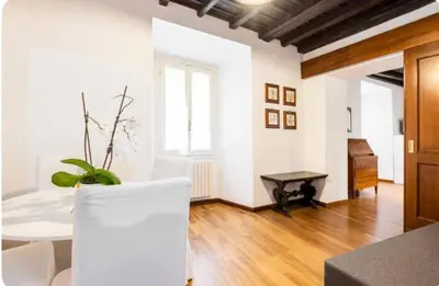 a living room with a table and a piano at Piazza Farnese house in Rome