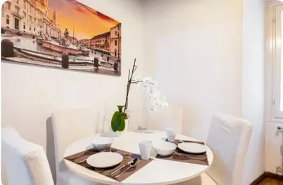 a white dining room with a white table and chairs at Piazza Farnese house in Rome