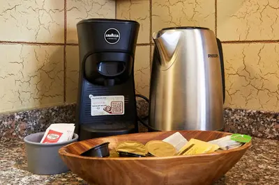 a coffee maker and a wooden bowl on a kitchen counter at Marco Polo House in Rome