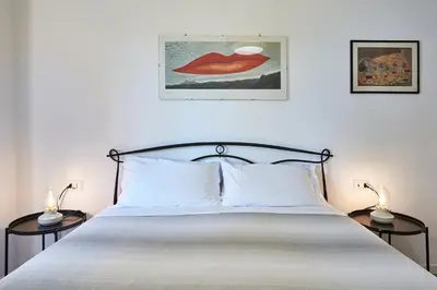 a bedroom with a bed with two lamps on either side at Marco Polo House in Rome