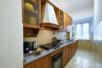a kitchen with wooden cabinets and a counter top at Marco Polo House in Rome