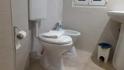 a bathroom with a white toilet and a sink at Casa Vacanze Nonno Giulio in Rome