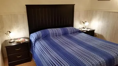 a bed with a blue comforter and two night stands at Casa Vacanze Nonno Giulio in Rome
