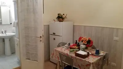 a kitchen with a table and a refrigerator at Casa Vacanze Nonno Giulio in Rome