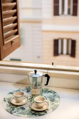 a glass tea pot and two cups on a plate at Domus Palestro in Rome