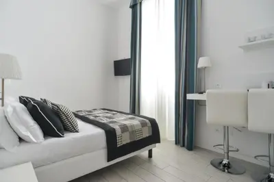 a white bedroom with a bed and a window at Lata Luxury Rooms in Rome