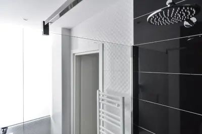 a bathroom with black and white tiled walls and a mirror at Lata Luxury Rooms in Rome