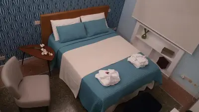 a small bedroom with a bed and a chair at Ad Vatican Suites in Rome