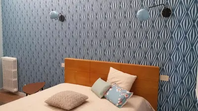 a bedroom with a bed with blue and white wallpaper at Ad Vatican Suites in Rome