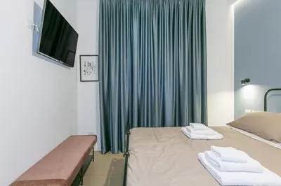 a room with two beds and a tv and green curtains at Appia Comfort Zone in Rome