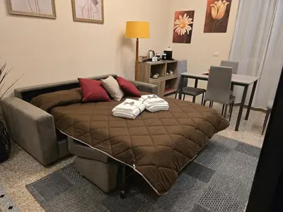 a bed in a living room with a table and chairs at Ritiro Romano in Rome