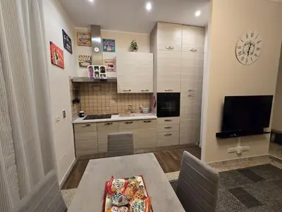 a kitchen with a table and a clock on the wall at Ritiro Romano in Rome