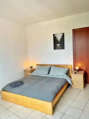 a bedroom with a large bed with two night stands at Basilica santa Maria ausiliatrice in Rome