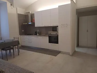 a kitchen with white cabinets and a table and a stove at Acquedotto di Nerone in Rome