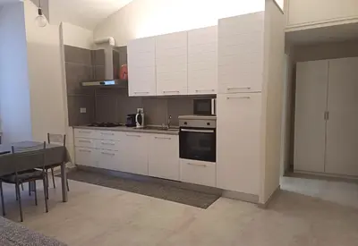 a kitchen with white cabinets and a stove top oven at Acquedotto di Nerone in Rome