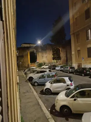 a row of parked cars in a parking lot at night at Acquedotto di Nerone in Rome