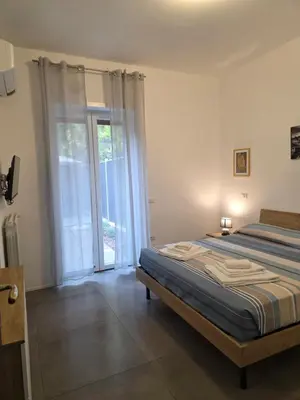 a bedroom with a bed and a sliding glass door at Alloggio Turistico A casa di Anna in Rome