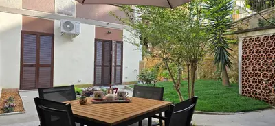 a wooden table and chairs in a patio with a yard at Alloggio Turistico A casa di Anna in Rome