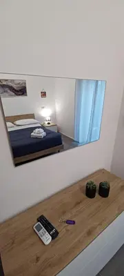 a mirror reflecting a bedroom with a bed and a remote control at Alloggio Turistico A casa di Anna in Rome