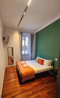 a bedroom with a large bed with a green wall at Mica Aurea Apartments Trastevere in Rome