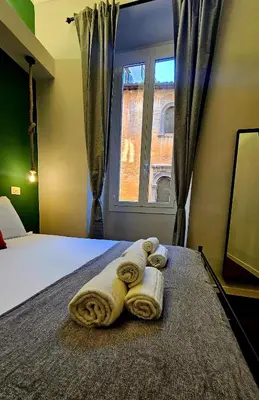 a bedroom with a bed with towels and a window at Mica Aurea Apartments Trastevere in Rome