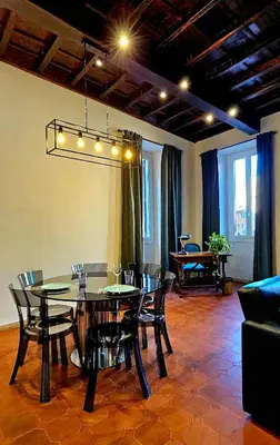 a dining room with a black table and chairs at Mica Aurea Apartments Trastevere in Rome