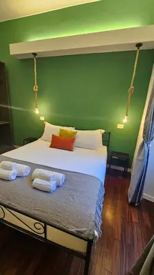 a green bedroom with a bed with towels on it at Mica Aurea Apartments Trastevere in Rome