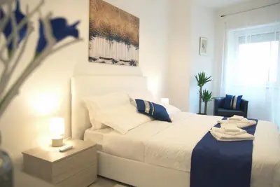 a bedroom with a white bed with a blue blanket at Vatican Malvi Domus in Rome
