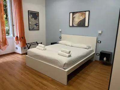 a bedroom with a large bed with white sheets at MNC House Roma in Rome