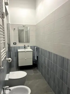 a bathroom with a sink and a toilet and a mirror at MNC House Roma in Rome
