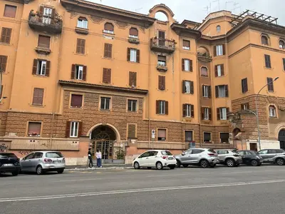 a large building with cars parked in front of it at MNC House Roma in Rome