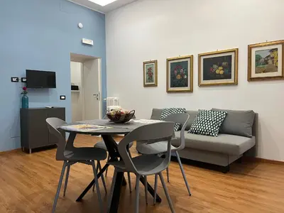 a living room with a table and chairs and a couch at MNC House Roma in Rome