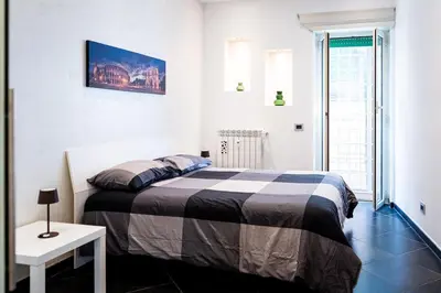 a white bedroom with a bed and a table at Sanpietrino Apartment in Rome