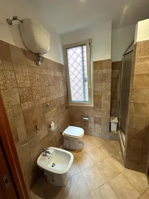 a bathroom with a toilet and a sink and a window at Alloggio turistico AVM in Rome