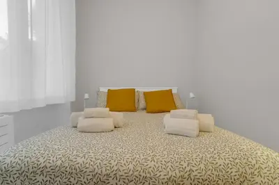 a large bed with yellow and white pillows on it at SANSO HOUSE - 2 bedrooms, 2 bathrooms, AC - for family in Rome