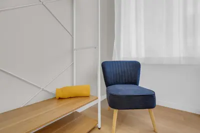 a blue chair sitting next to a wooden table at SANSO HOUSE - 2 bedrooms, 2 bathrooms, AC - for family in Rome