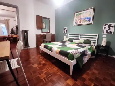 a bedroom with a bed with a green and white comforter at BedEpoque - Camera 1 in Rome