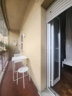 a table and a chair on a balcony at BedEpoque - Camera 1 in Rome