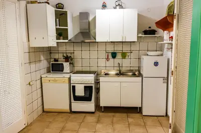 a small kitchen with white appliances and white cabinets at Domus Vaticanae in Rome