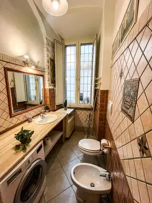 a bathroom with a toilet and a sink and a washing machine at Domus Vaticanae in Rome
