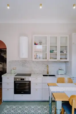 a kitchen with white cabinets and a table at Modern apartment in Cornelia in Rome